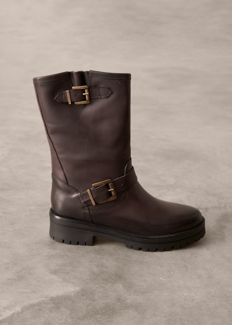 Brown leather boot with buckles on a gray background