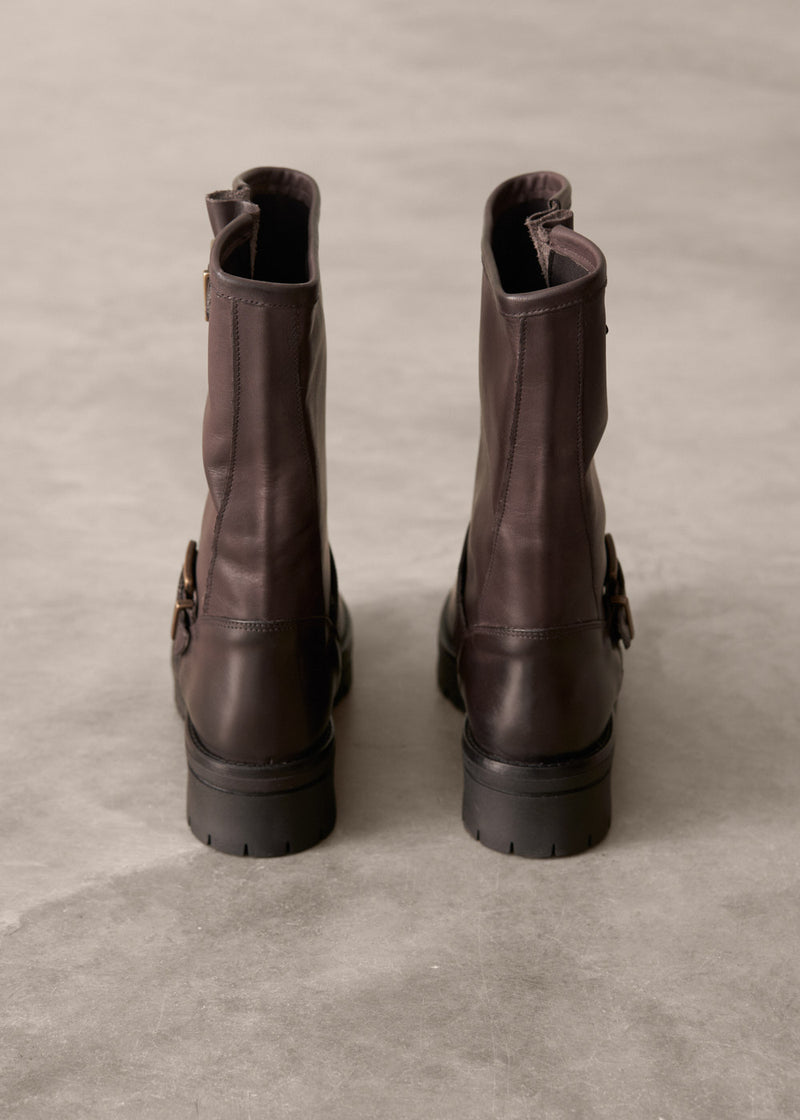 Pair of brown leather boots on a textured gray surface