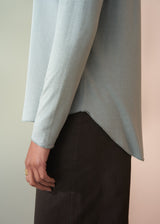 Light gray sweater worn by a person on a neutral background