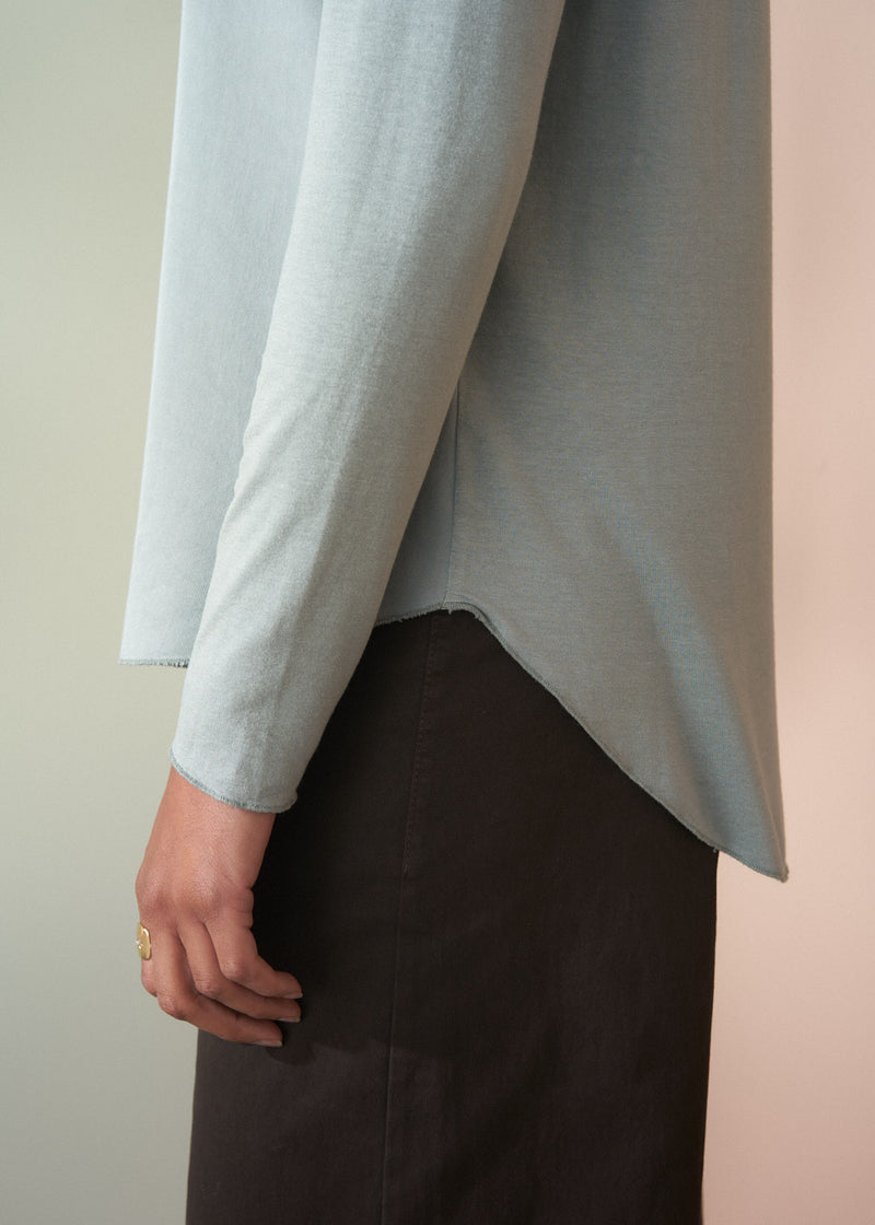 Light gray sweater worn by a person on a neutral background