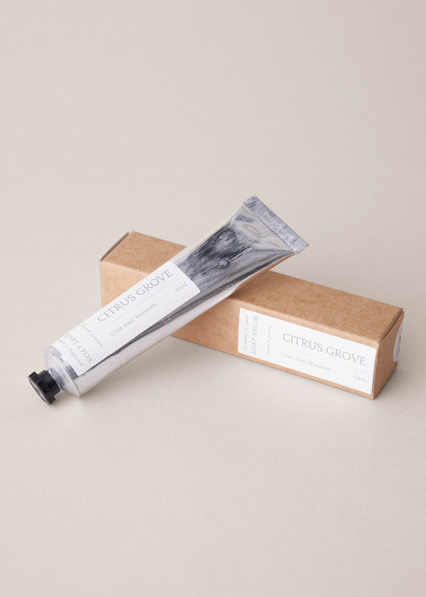 Hand cream tube with packaging on a beige background
