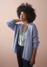 Women wearing dusky lavender chunky oversized knit cardigan with a floral long sleeved top.