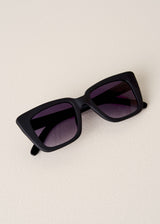 Black sunglasses with dark lenses on a beige background