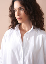 Woman wearing a white shirt against a beige background