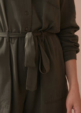 Dark green dress with a belt on a neutral background