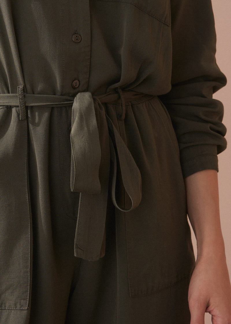 Dark green dress with a belt on a neutral background