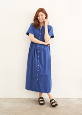 A model wearing a blue relaxed fit button down shirt dress with short sleeves