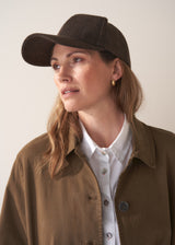 Woman wearing brown coat and brown herringbone cap