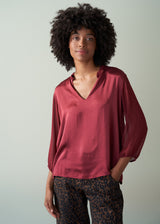 Woman wearing a red blouse with a neutral background