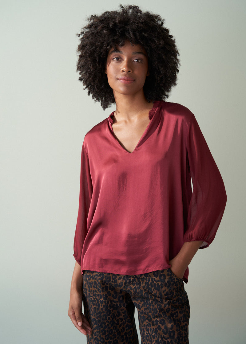Woman wearing a red blouse with a neutral background
