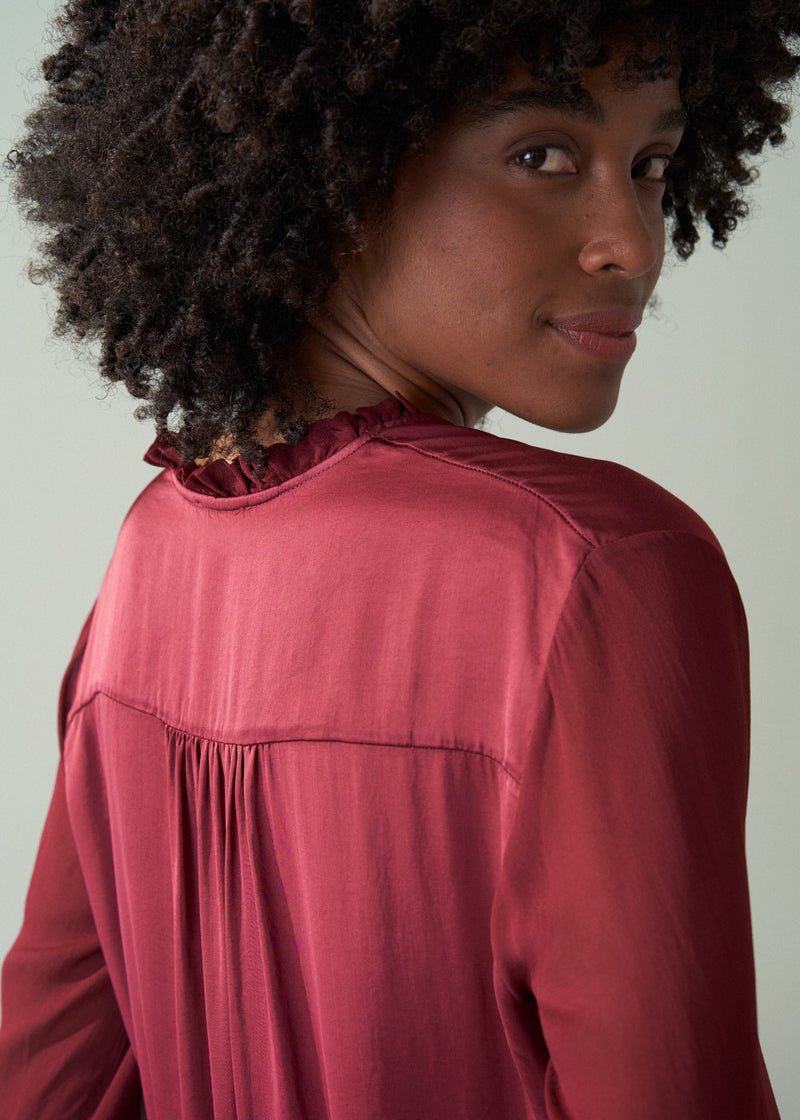 Woman wearing a pink blouse with a plain background