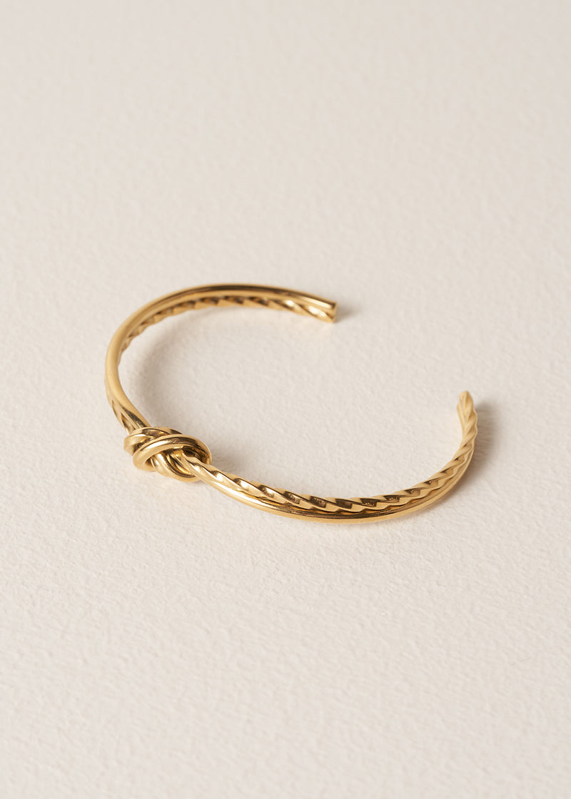 Gold bracelet on a beige background