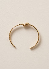 Gold bracelet on a beige background