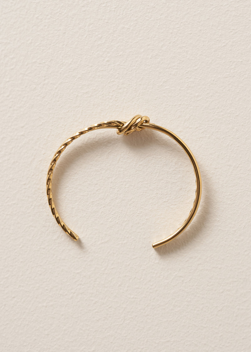 Gold bracelet on a beige background