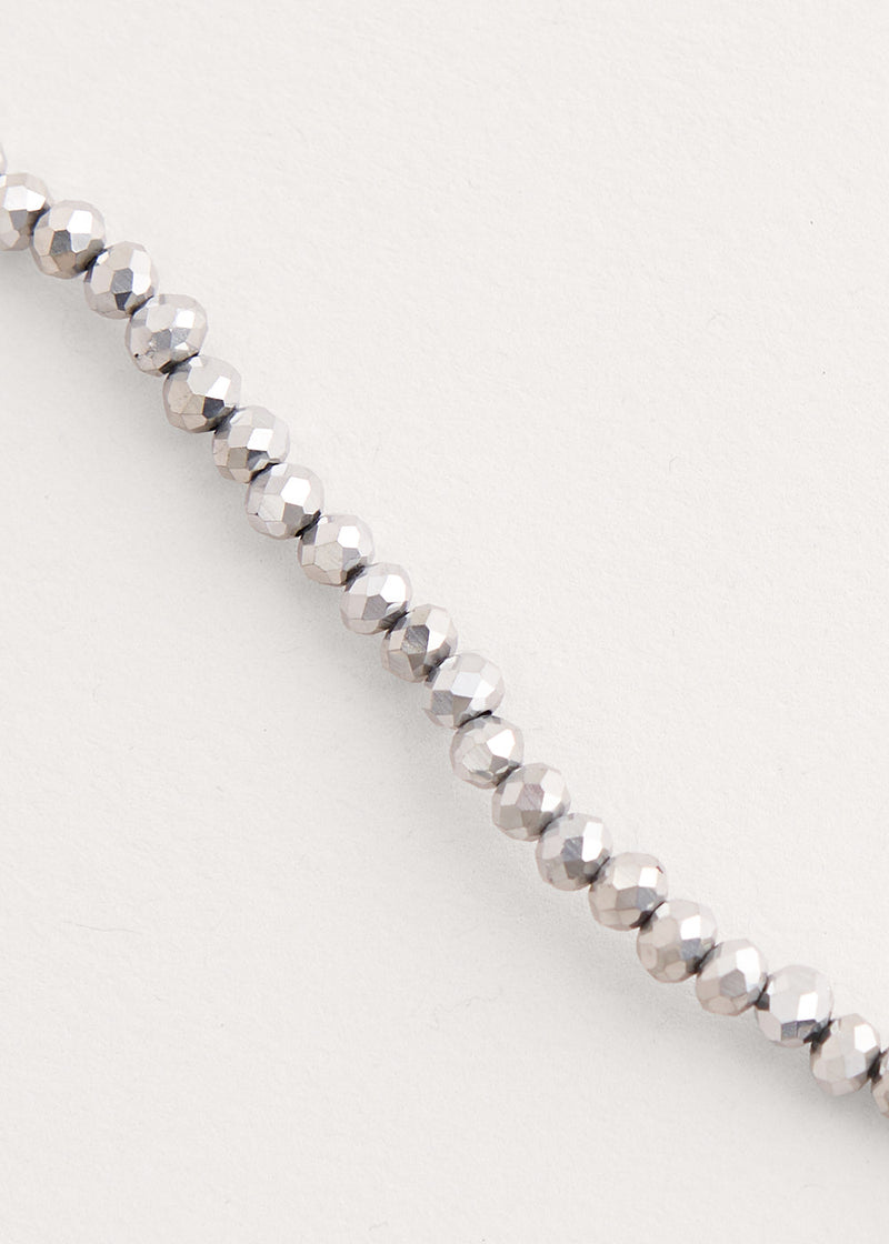 A long beaded necklace comprised of silver crystals