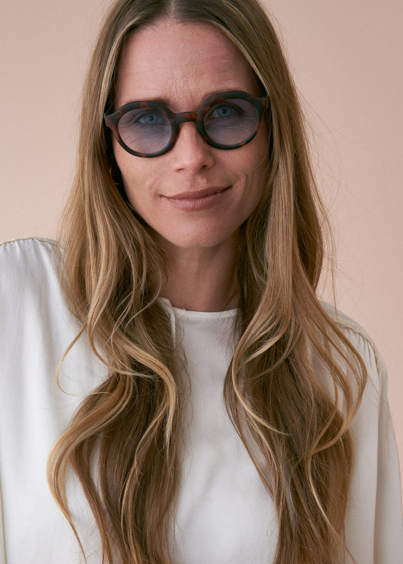 Oversized circular sunglasses with tortoiseshell pattern and blue lenses