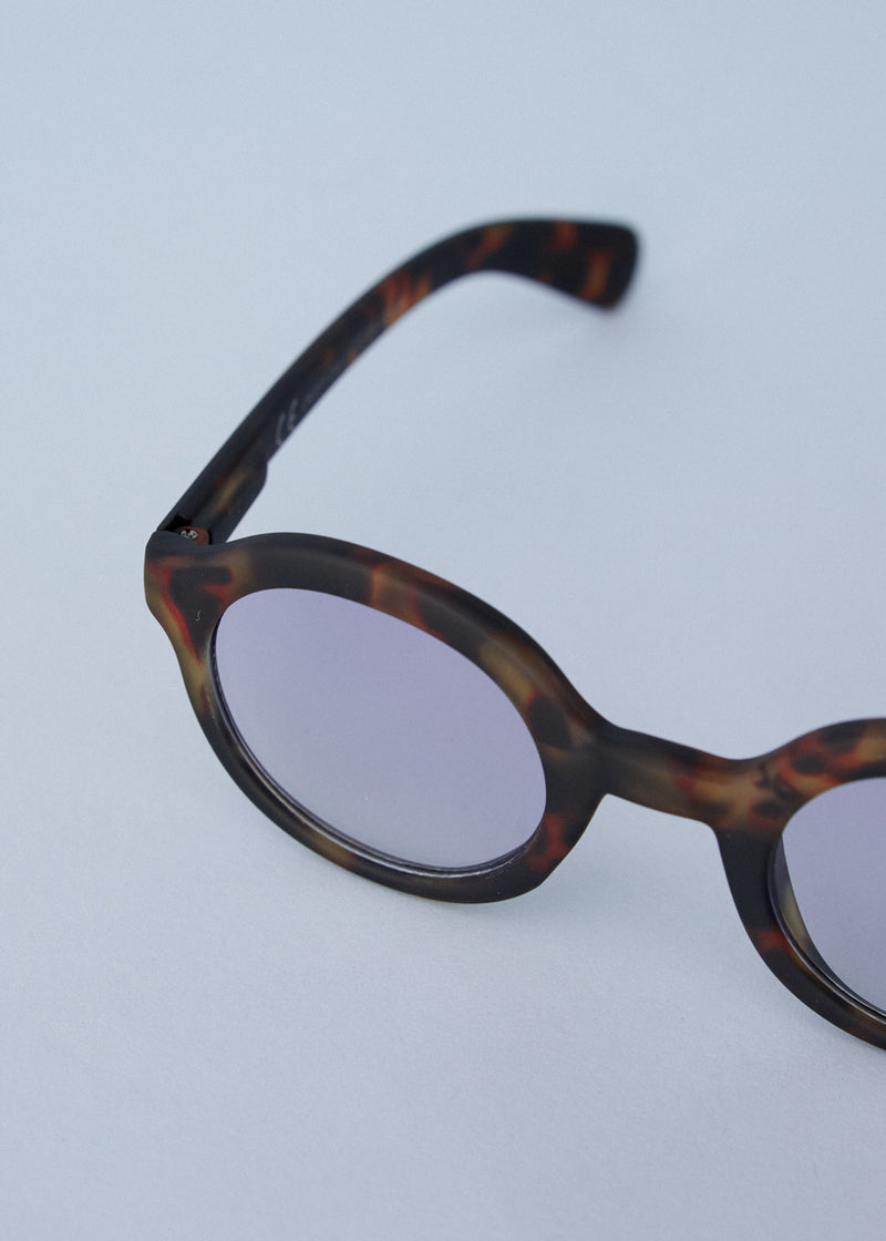Oversized circular sunglasses with tortoiseshell pattern and blue lenses