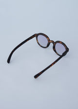 Oversized circular sunglasses with tortoiseshell pattern and blue lenses