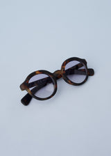 Oversized circular sunglasses with tortoiseshell pattern and blue lenses