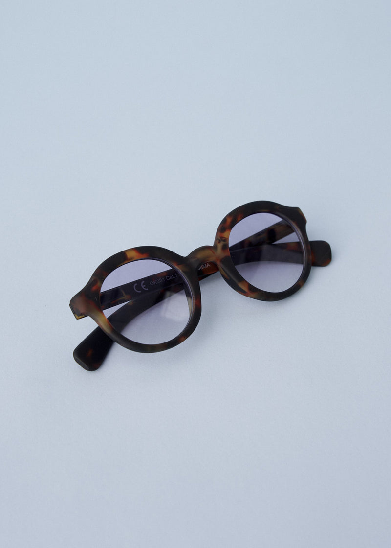 Oversized circular sunglasses with tortoiseshell pattern and blue lenses