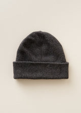 A dark gray knit beanie hat with a folded cuff, displayed flat against a light beige background.