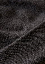 Close-up of a dark charcoal gray knit fabric texture with soft folds and a ribbed pattern.