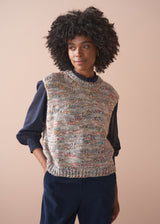 Woman wearing a sleeveless space dye sweater vest against a beige background