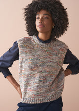 Woman wearing a knitted vest with a textured space dye against a beige background
