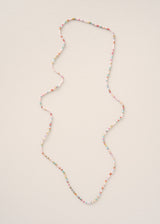 A long beaded necklace with small multicoloured beads arranged in an irregular, organic shape, displayed on a plain off-white background.
