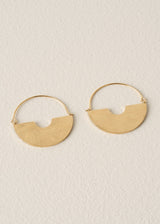 Pair of gold hoop earrings on a beige background