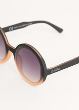 A pair of chunky circular sunglasses with black and pink frames and blue lenses