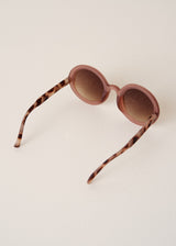 Sunglasses with tortoiseshell arms on a light beige background