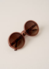 Brown round sunglasses on a beige background