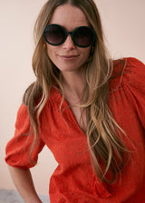 A model wearing a pair of oversized black circular sunglasses