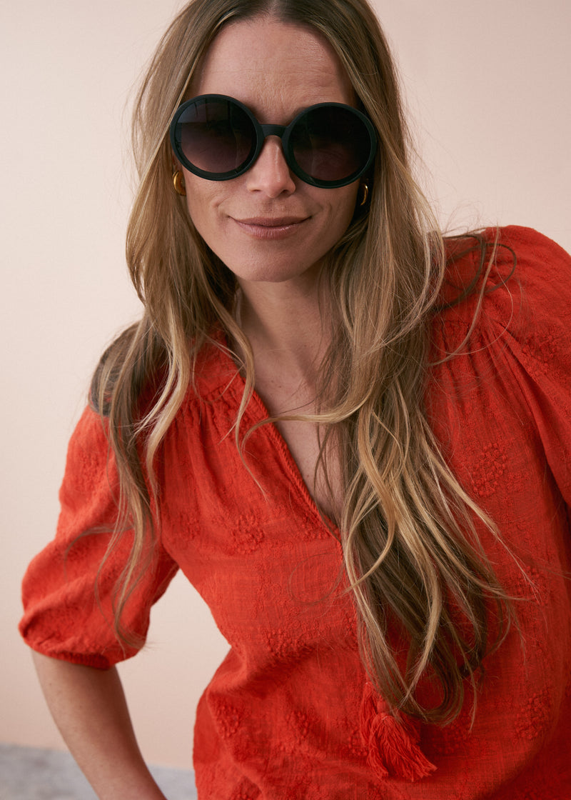 A model wearing a pair of oversized black circular sunglasses