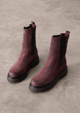 Pair of Burgundy Chelsea boots on a gray concrete surface