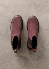 Pair of Burgundy Chelsea boots on a gray concrete surface