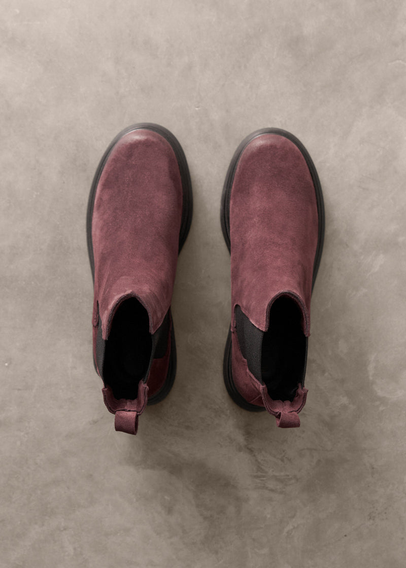 Pair of Burgundy Chelsea boots on a gray concrete surface