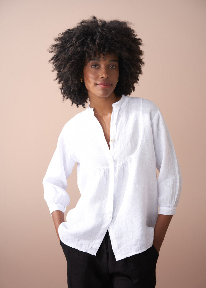 Woman wearing a white shirt against a beige background