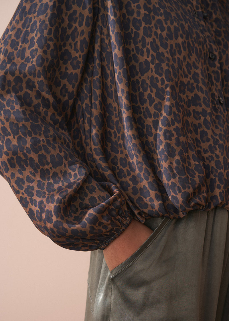 Close-up of a leopard print bubble hem shirt with a plain background