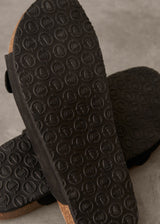 Close-up of black rubber sole with tread pattern on a neutral background