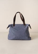 Blue bag with brown leather handles on a beige background