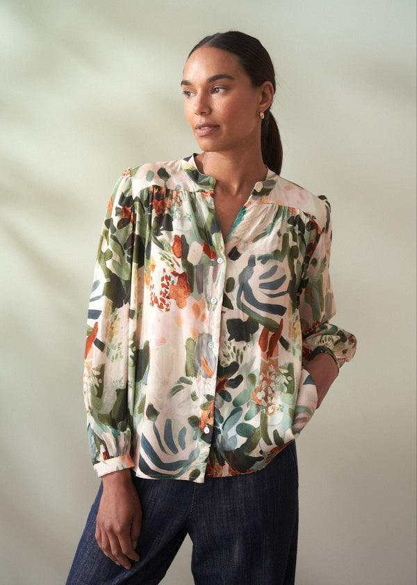 Woman wearing a floral blouse against a plain background