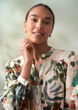 Woman wearing a floral blouse against a plain background