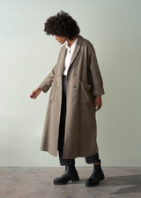 Person wearing a long checkered coat against a plain background