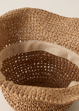 Inside of a floppy straw hat against a beige background