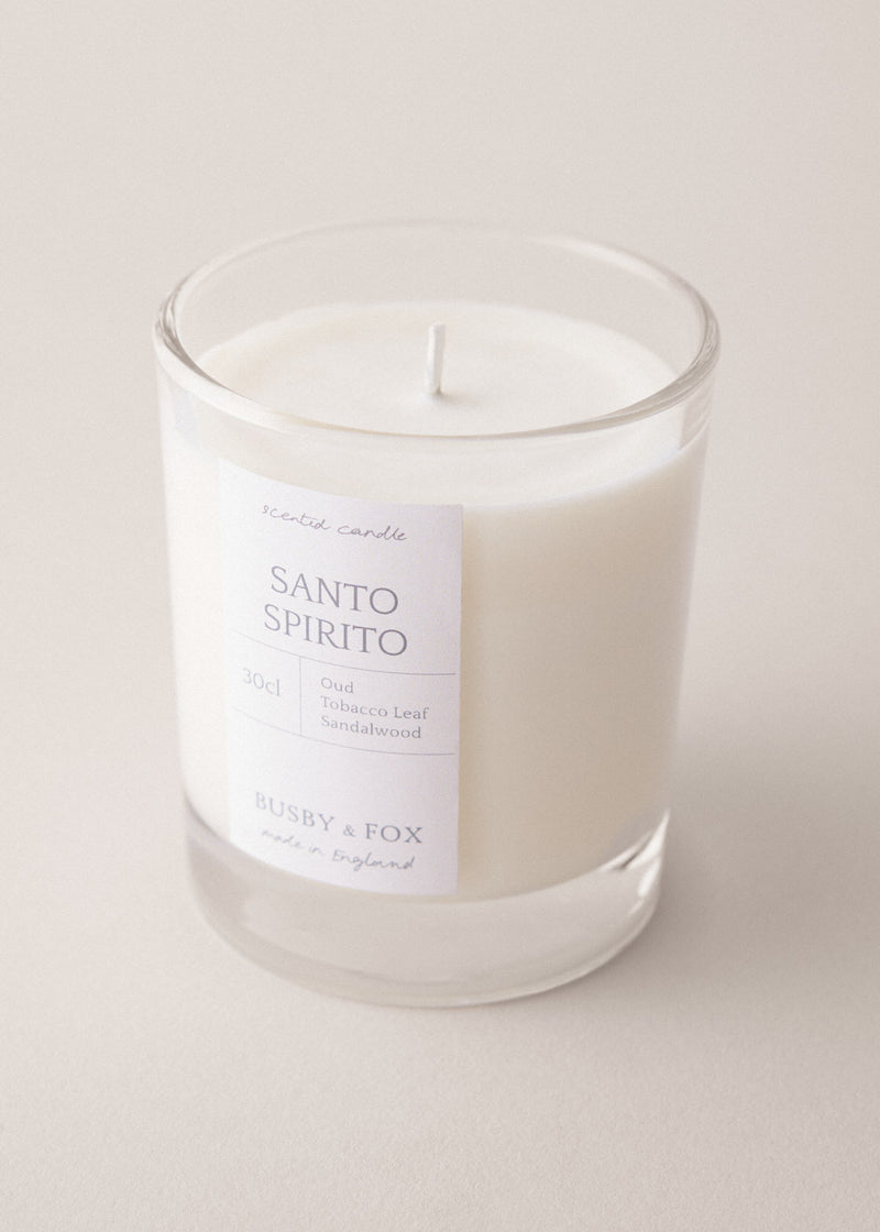 Santo Spirito candle in a glass jar with a white label on a light background