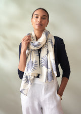Woman wearing a patterned scarf against a plain background