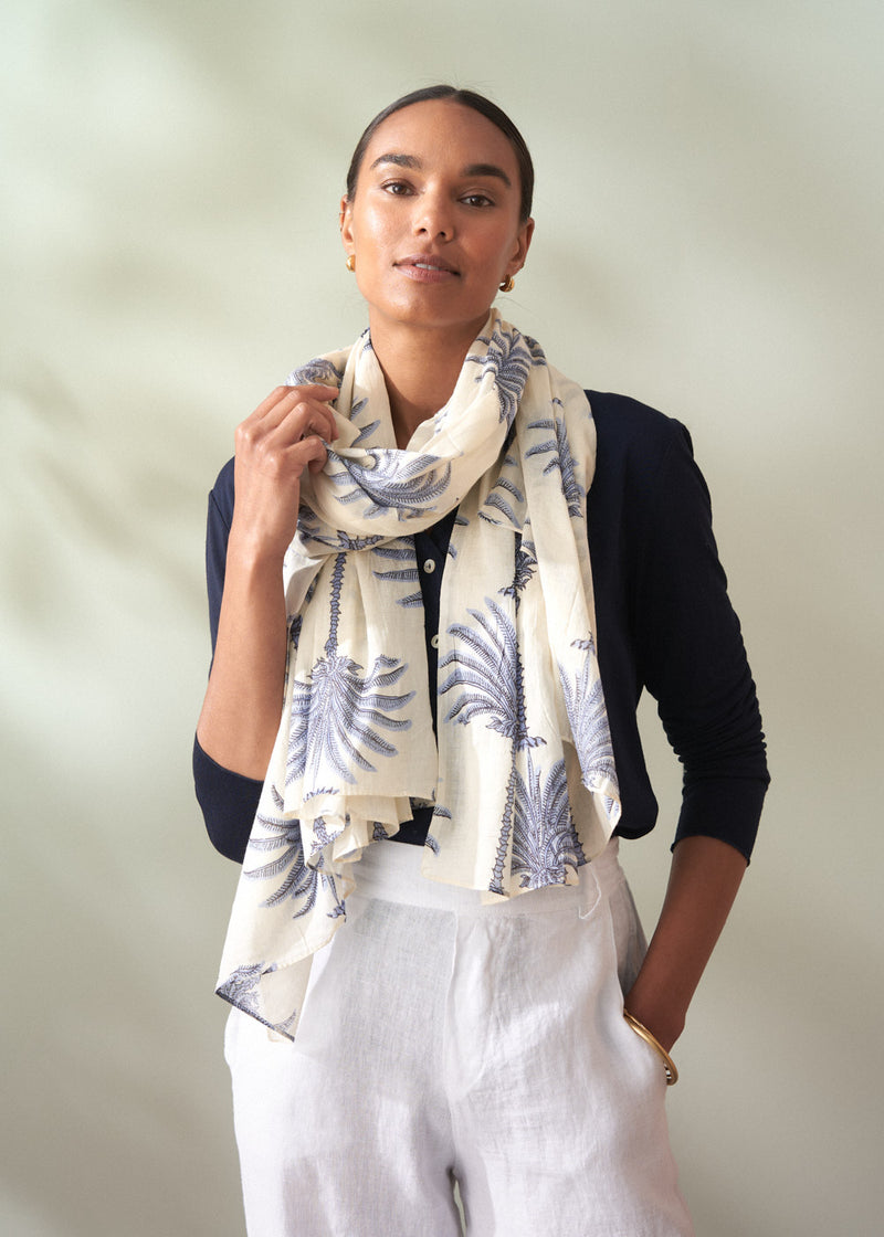Woman wearing a patterned scarf against a plain background