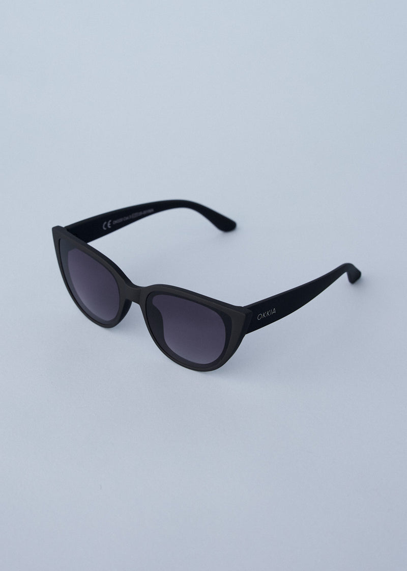 A pair of oversized cat eye sunglasses with black frames and blue lenses